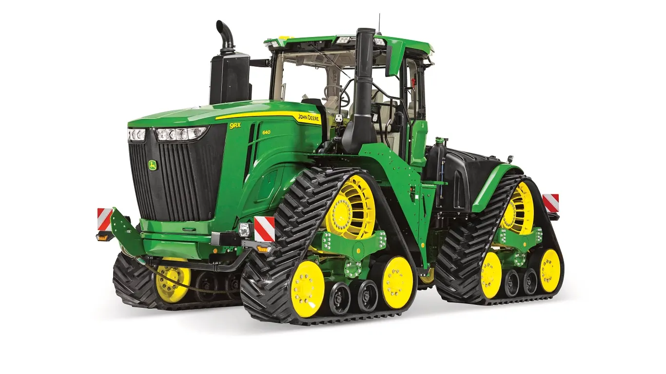 Τρακτέρ John Deere 9RX με τέσσερις ερπύστριες, σε λευκό φόντο, με μπροστινή δεξιά γωνία και ανεξάρτητες ερπύστριες από καουτσούκ και πλήρη καμπίνα