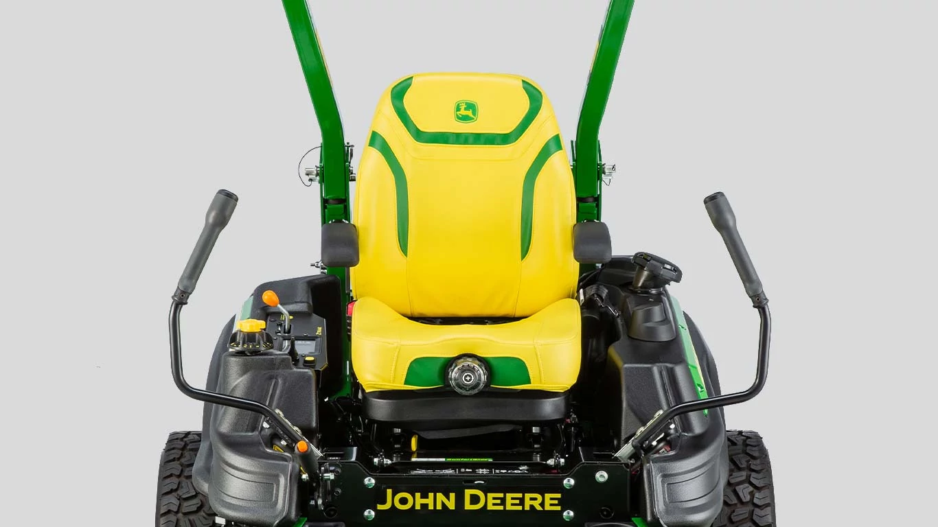 Χορτοκοπτικό με ανυψωμένο το μπροστινό κάθισμα, επιδεικνύοντας τον σχεδιασμό και τη λειτουργία του σε καλά συντηρημένο εξωτερικό χώρο.