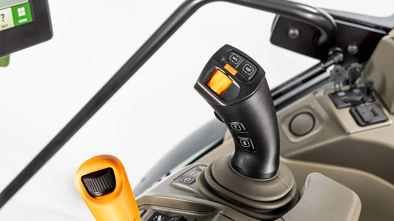 Κοντινή άποψη του τιμονιού του τρακτέρ και της αλλαγής ταχυτήτων, που δείχνει τον περίπλοκο σχεδιασμό και τη λειτουργικότητα των χειριστηρίων.