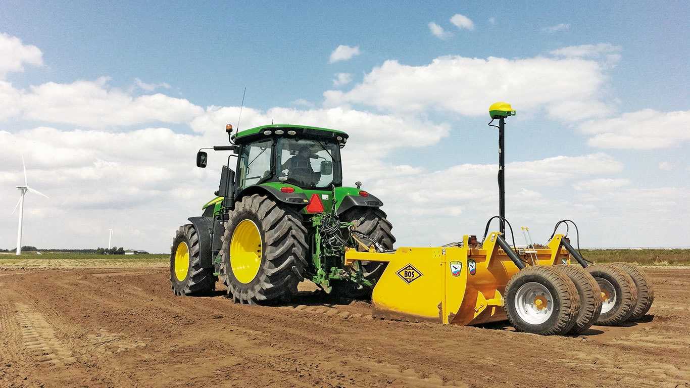 Λήψη δράσης Τρακτέρ μεγάλων τροχών με παρελκόμενο αγρού iGrade™ - Πίσω αριστερή όψη