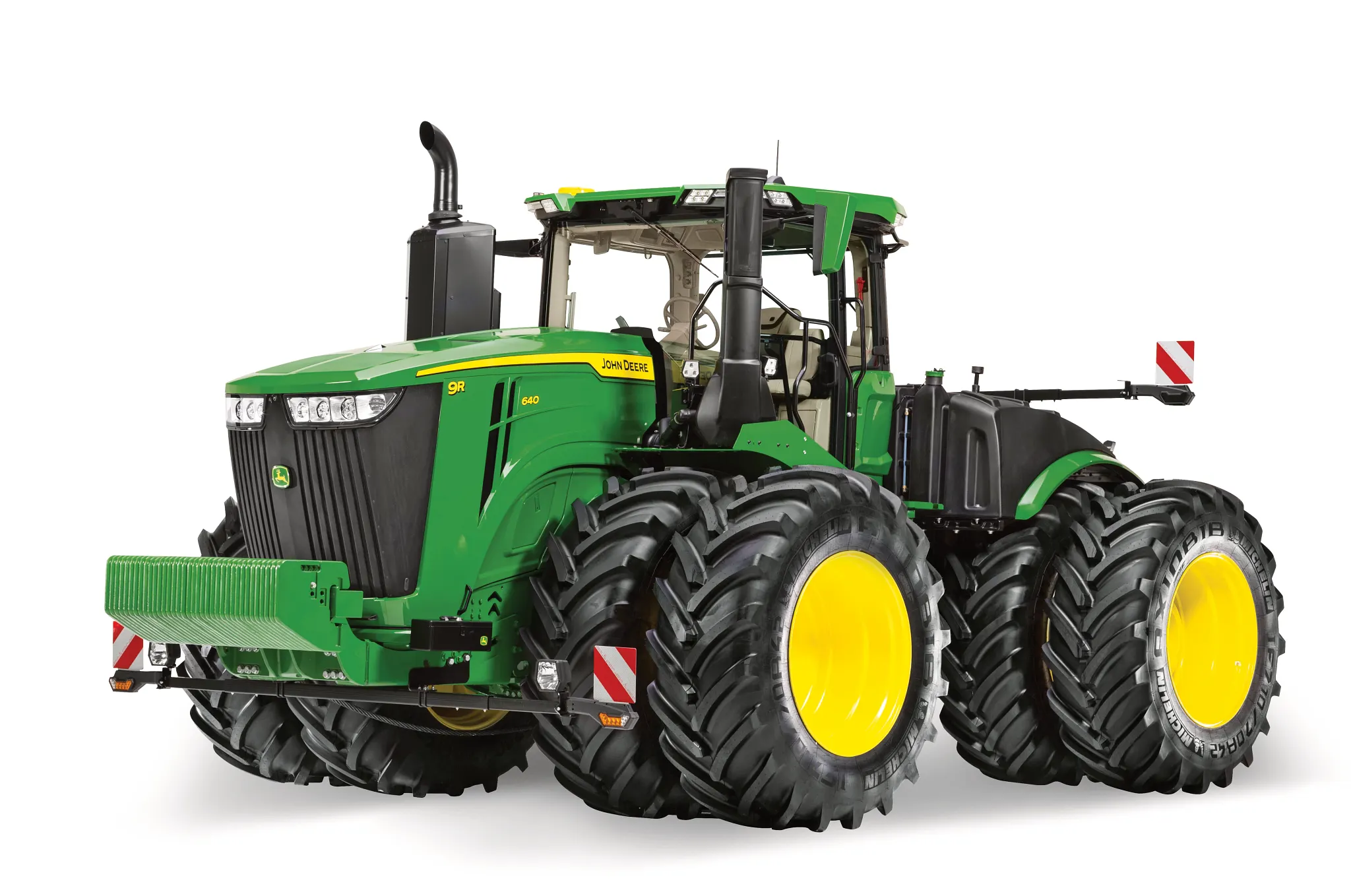 Αρθρωτό τρακτέρ 9R της John Deere με διπλούς πίσω τροχούς σε λευκό φόντο, σε απεικόνιση από εμπρός δεξιά γωνία με πλήρη καμπίνα και μπλοκ αντίβαρων