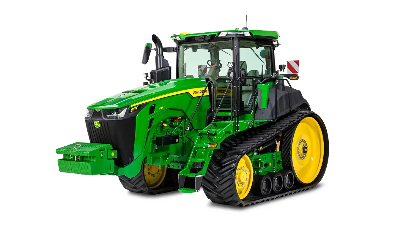 Τρακτέρ 8RT με ερπύστριες της John Deere από μπροστά δεξιά σε λευκό φόντο, με λαστιχένιες ερπύστριες, μπροστινό μπλοκ αντίβαρων και πλήρη καμπίνα