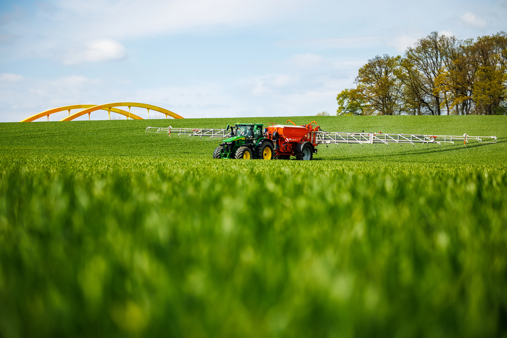 Το τρακτέρ 7R 350 τραβάει έναν διασκορπιστή λιπάσματος στον αγρό