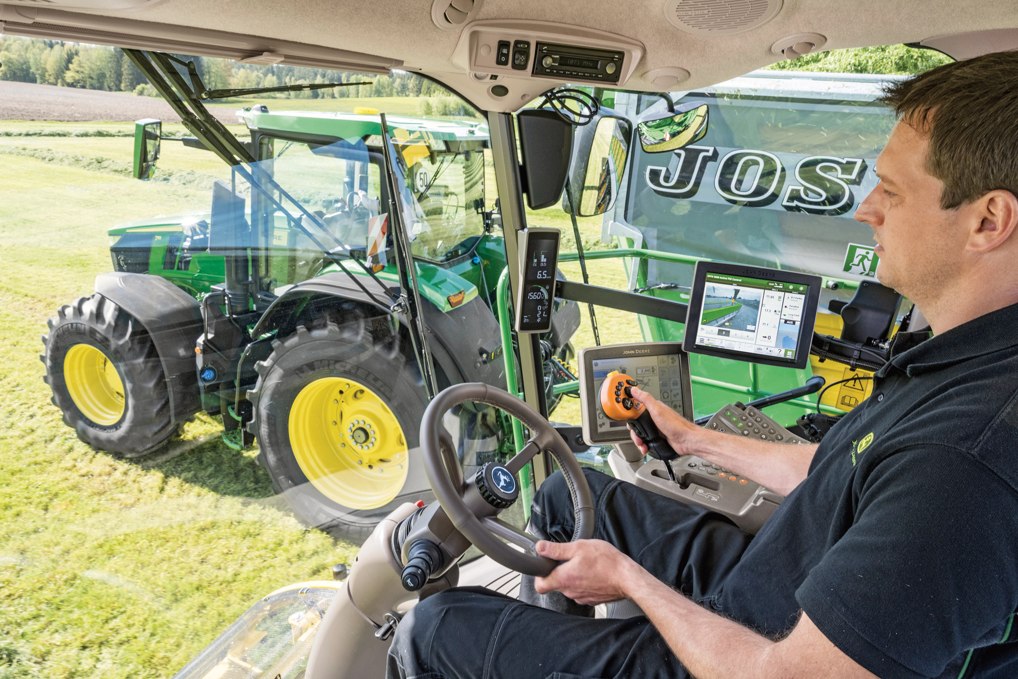 Ο άνθρωπος στην καμπίνα χειρίζεται το τιμόνι και τον μοχλό πολλών λειτουργιών στον αγρό