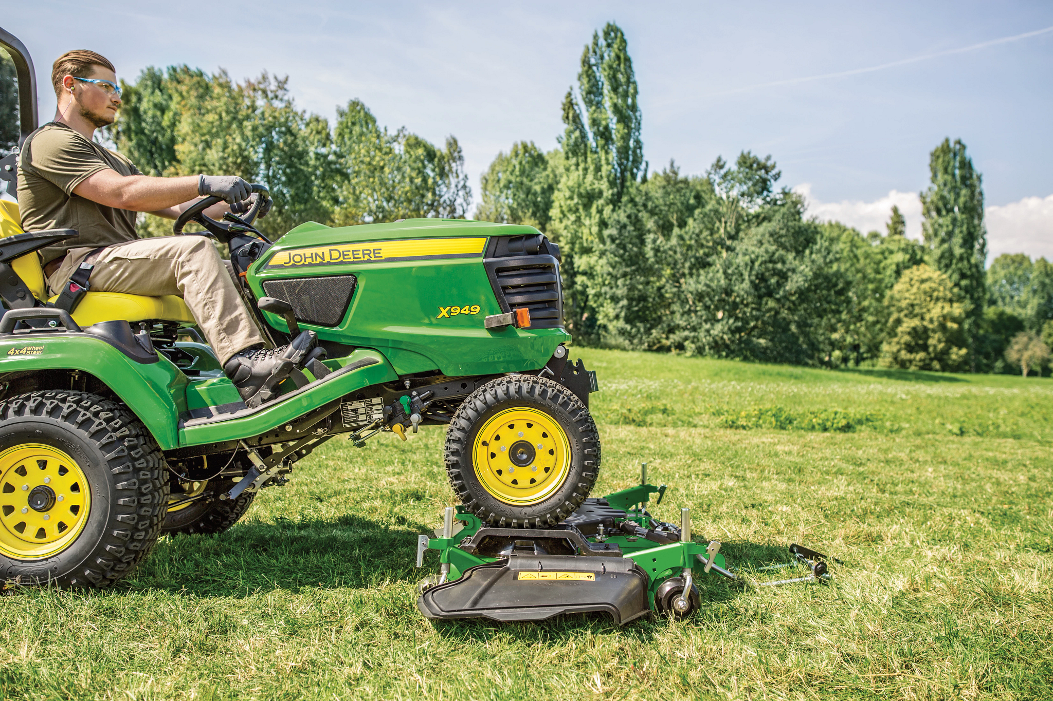 Ένας άνθρωπος οδηγεί το X949 πάνω στην πλατφόρμα οδήγησης στον αγρό