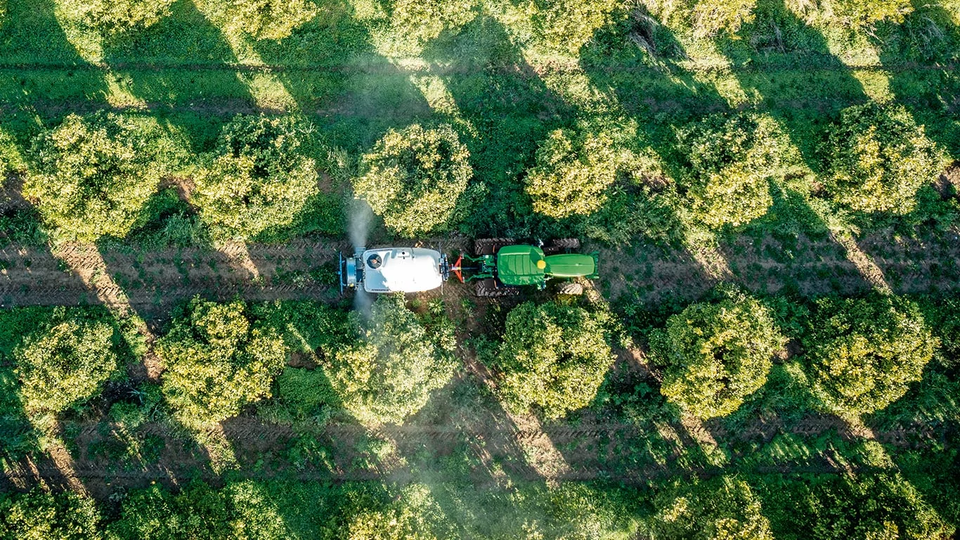 Κάτοψη τρακτέρ που έλκει ρυμουλκούμενο ψεκαστικό μέσα από οπωρώνες