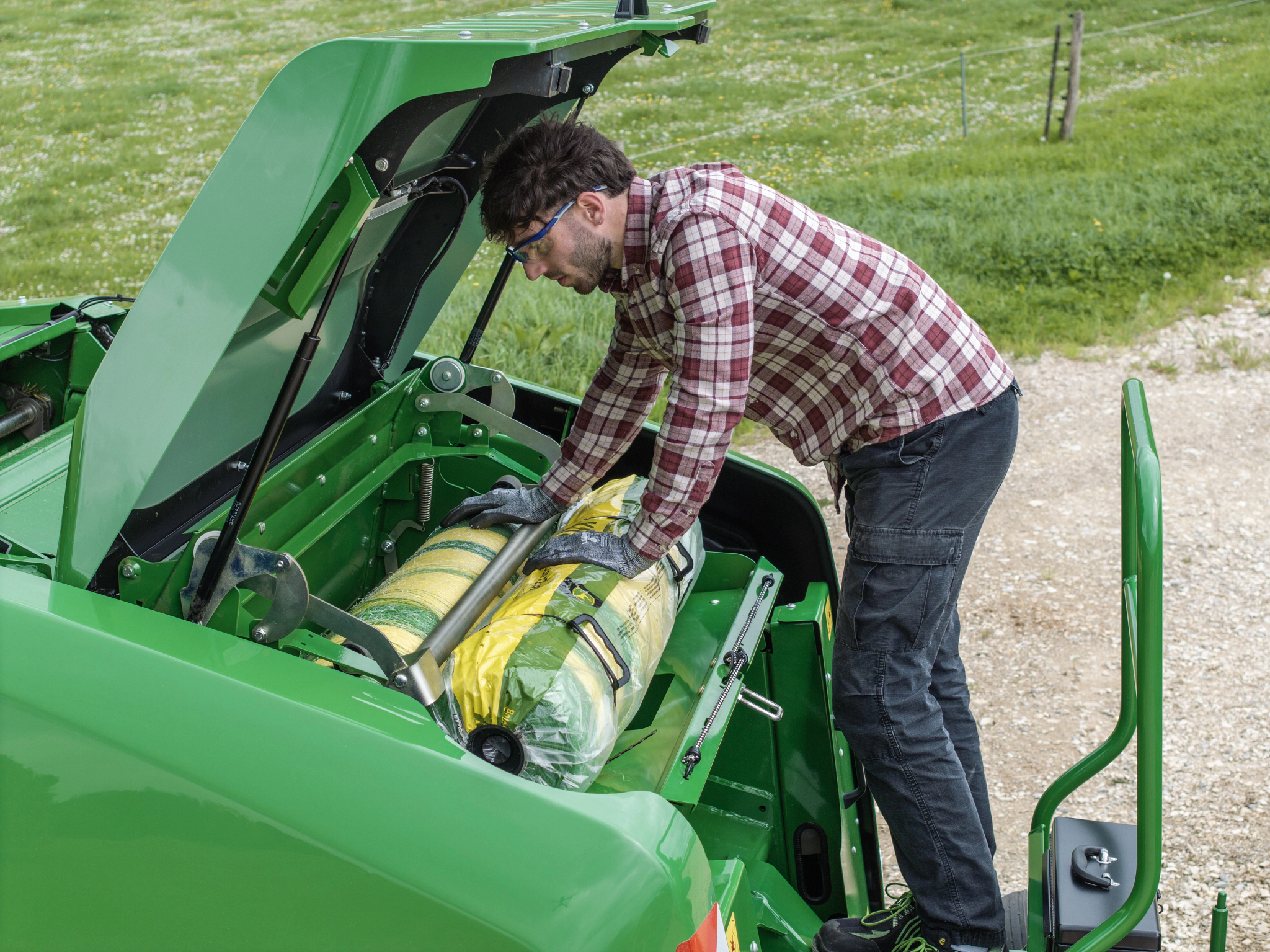 Ο χειριστής αντικαθιστά ομαλά το δίχτυ περιτύλιξης σε ένα χορτοδετικό κυλινδρικών δεμάτων