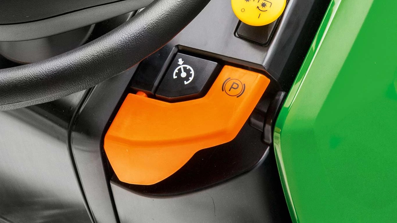 Κοντινό πλάνο των πλήκτρων ελέγχου ταχύτητας πορείας και φρένου στάθμευσης σε χλοοκοπτικό τρακτέρ σειράς X500