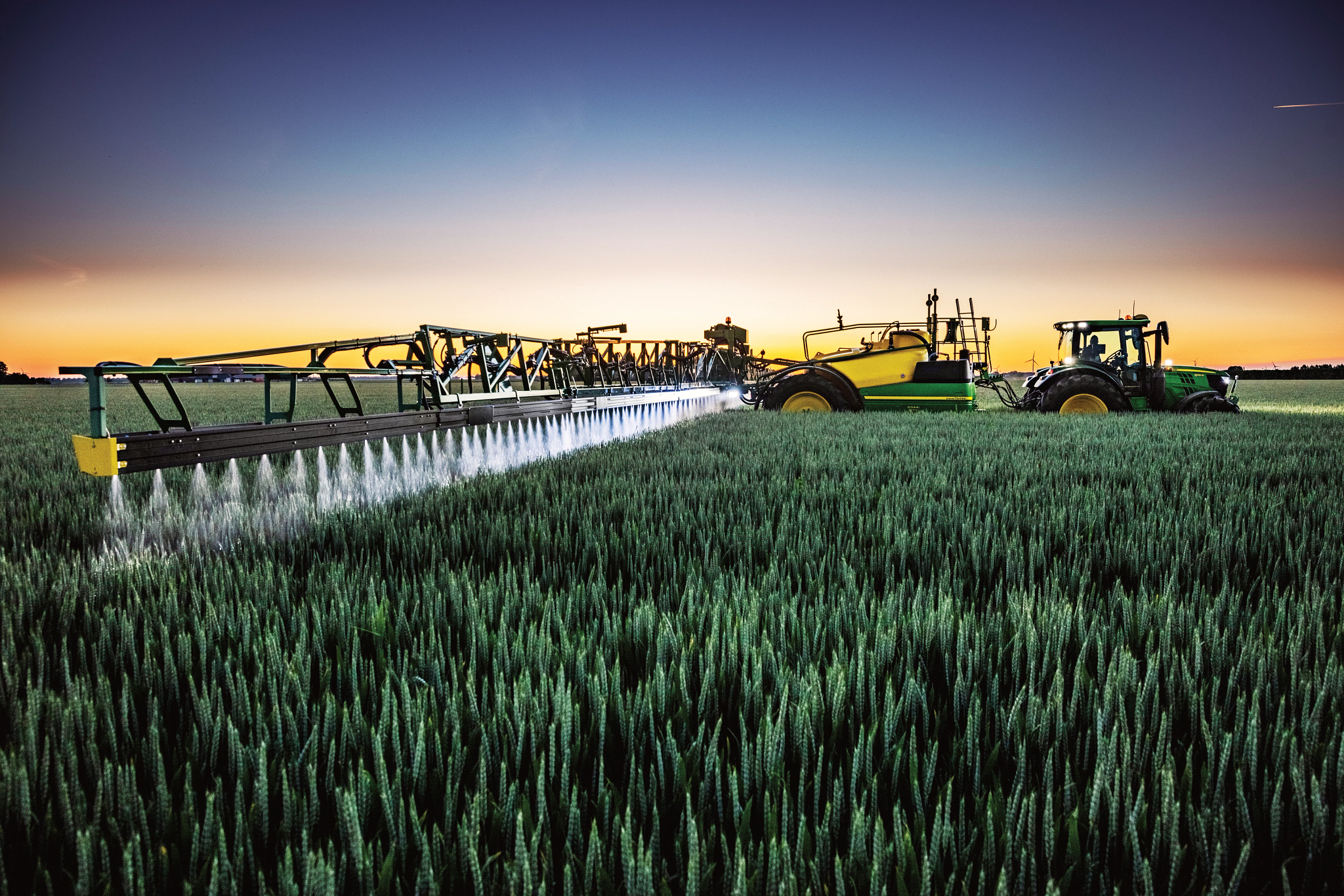 Όψη δεξιάς πλευράς ενός τρακτέρ που έλκει ένα ψεκαστικό στον αγρό