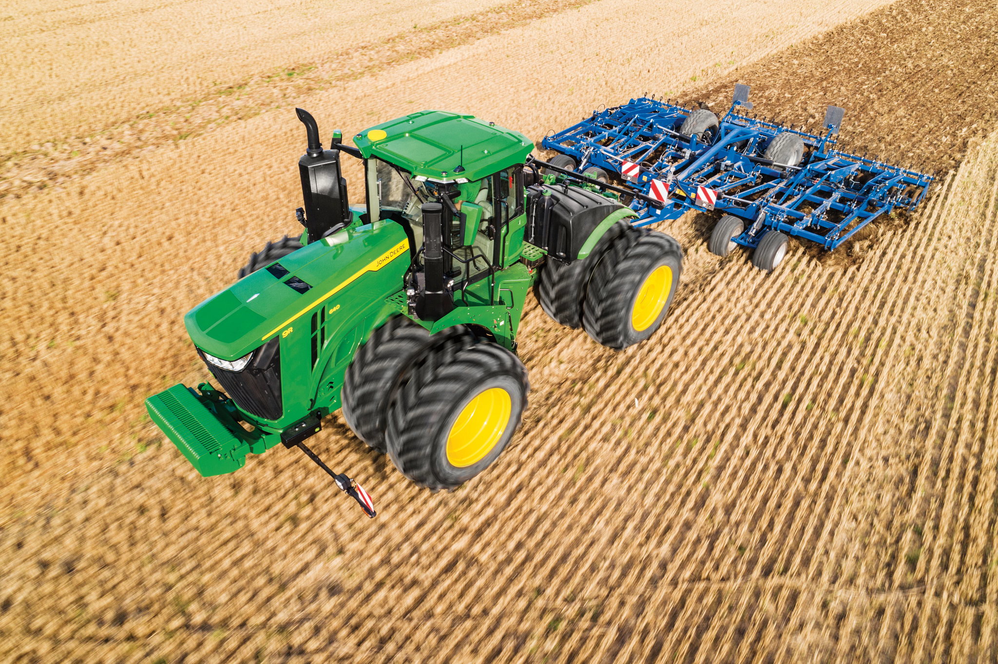 Τρακτέρ σειράς 9R που έλκει παρελκόμενο οργώματος σε αγρό