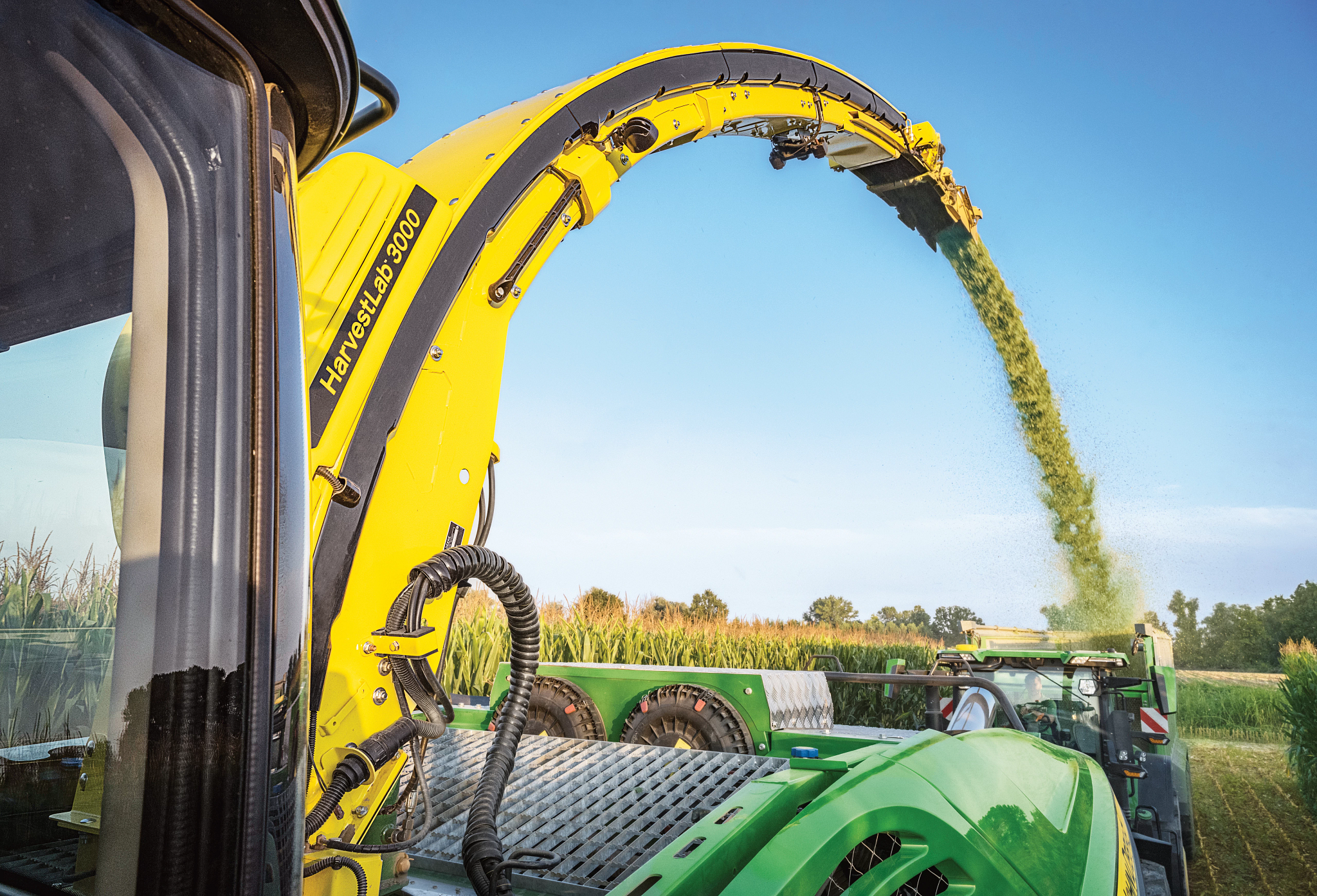 Κοντινή λήψη του στομίου σωλήνα εκκένωσης για τον ψεκασμό ενσιρώματος από αυτοκινούμενο ενσιρωκοπτικό μηχάνημα στον αγρό