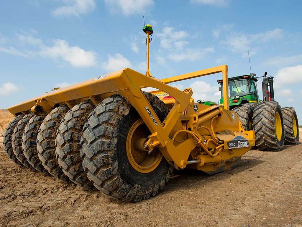 Το τρακτέρ τραβάει έναν αποξέστη στον αγρό