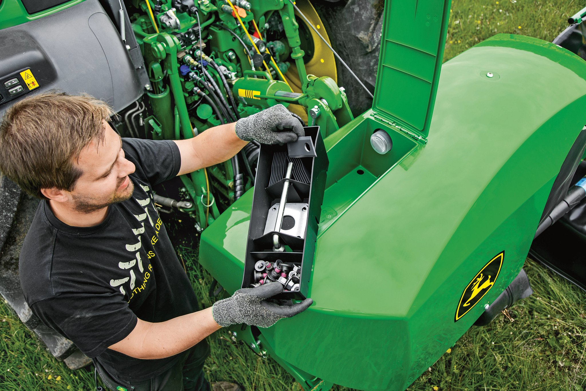 Κάτοψη άνδρα που χρησιμοποιεί εργαλειοθήκη χορτοκοπτικού με τρακτέρ και σύστημα ζεύξης