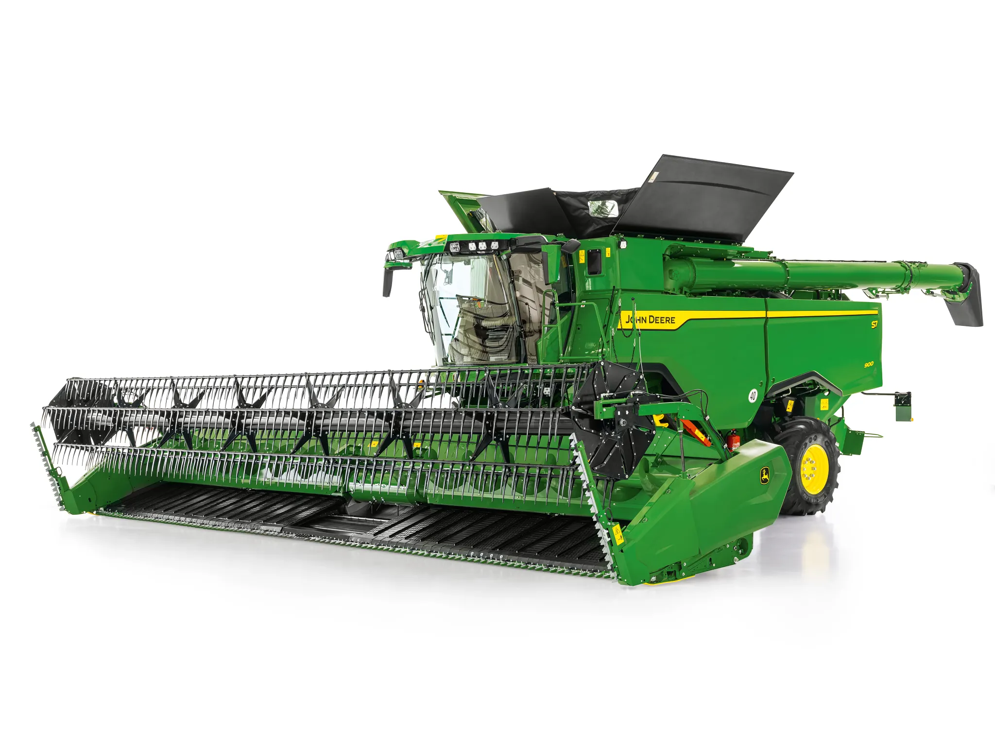 Θεριζοαλωνιστική John Deere με φαρδιά κεφαλή κοπής σπόρων σε λευκό φόντο, που δείχνει τον πλήρη σχεδιασμό του μηχανήματος και το μπροστινό σύστημα κοπής.