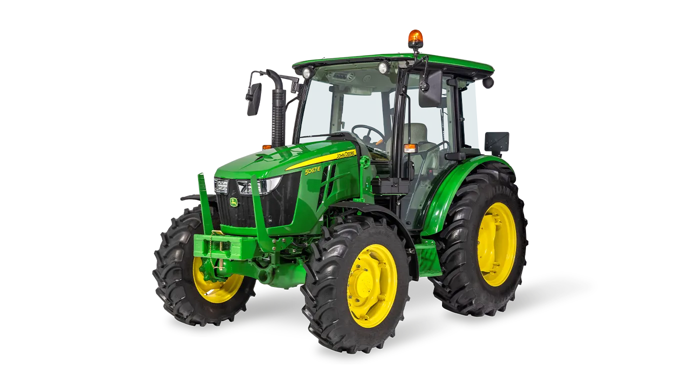 Τρακτέρ γενικής χρήσης John Deere 5067E με κλειστή καμπίνα σε απεικόνιση υπό γωνία μπροστά-δεξιά σε λευκό φόντο, με γεωργικά ελαστικά
